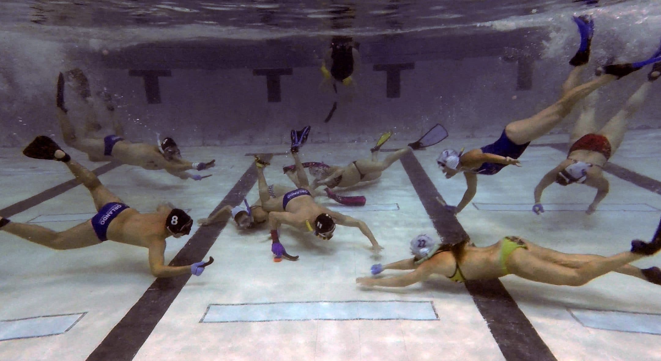 Underwater hockey players practicing